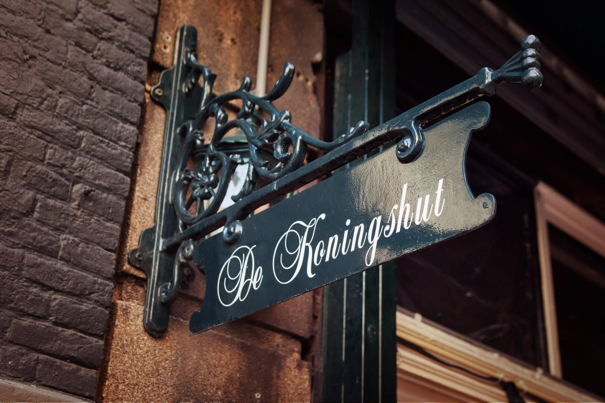 Het smeedijzeren uithangbord van De Koningshut aan de gevel